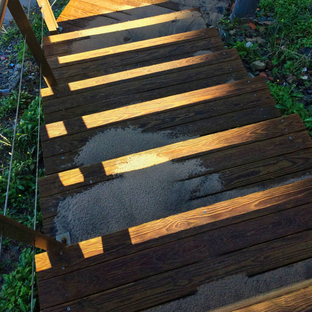 strome drewniane schody prowadzące w dół, piasek rozrzucony po schodach, promienie słoneczne grają na drewnie - steep road footpath moving down zdjęcia i obrazy z banku zdjęć