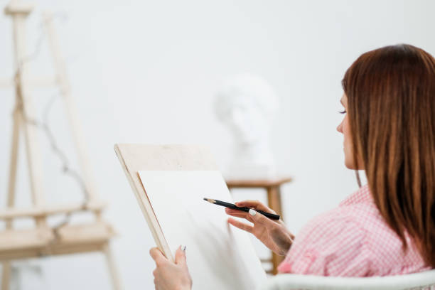istock Young woman artist draws a pencil on canvas. 1125404113