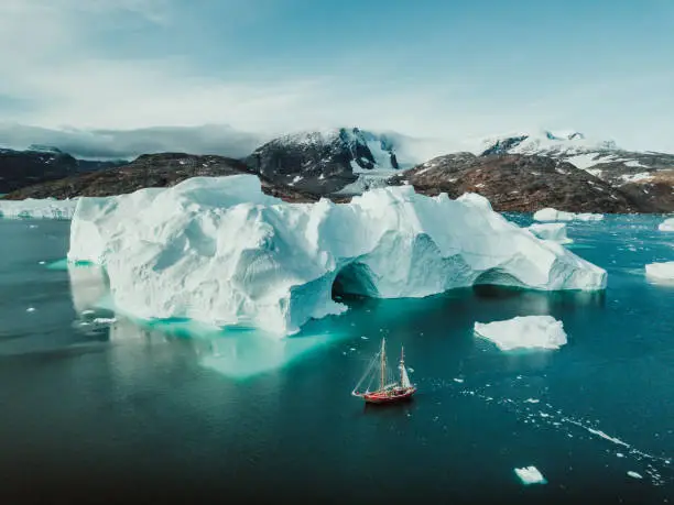 Photo from an expedition with a sailing boat through the beautiful vast landscape of huge icebergs and impressive mountainscapes in East Greenland.