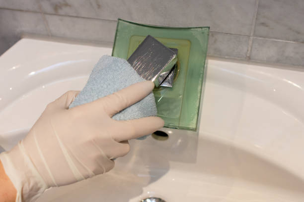 istock Hands with rubber protective gloves cleaning tap with cloth 1125408428