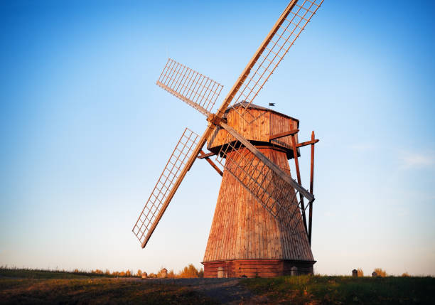 A windmill is standing in a field in Arkaim Ural Russia. The windmill is old and has a wooden structure