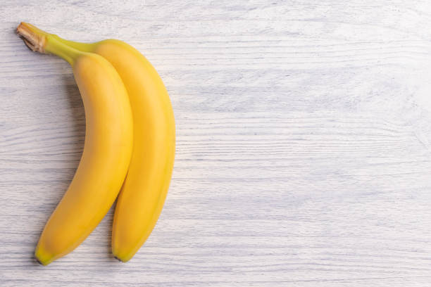 Sweet bananas on white wooden table