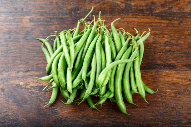istock green beans on wooden brown background. 1125413593