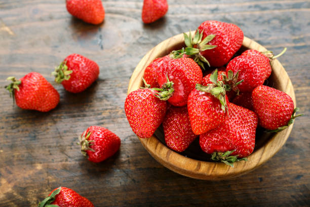 istock strawberries in a wooden plate on the table 1125413785