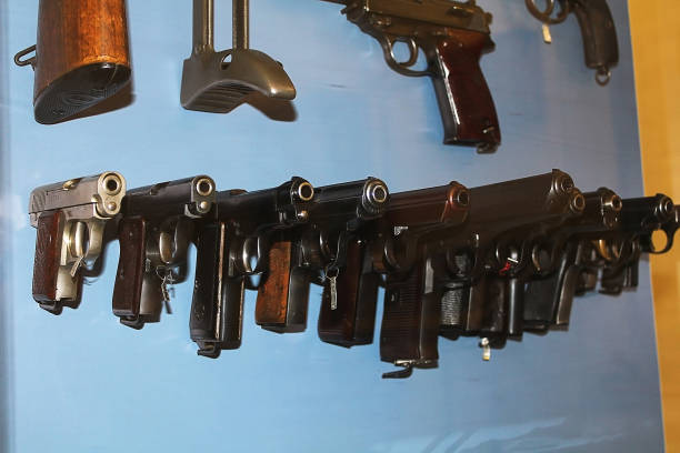 Antique pistols on velvet burgundy fabric in a wooden box. Two gun barrels.