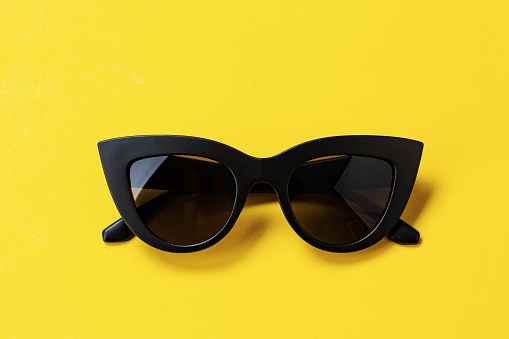 Women's retro sunglasses cat or fox on a bright yellow background. space for text
