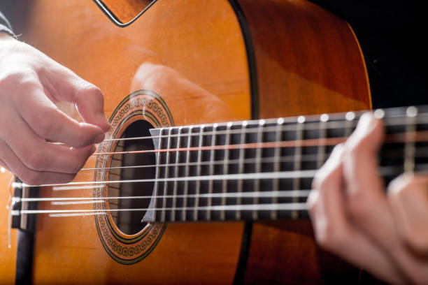 istock adult white guy playing an acoustic guitar. Backlit shooting 1125417834
