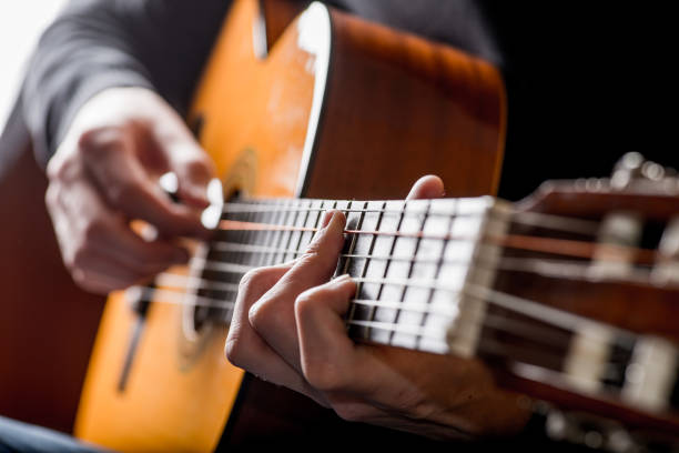 istock adult white guy playing an acoustic guitar. Backlit shooting 1125417837