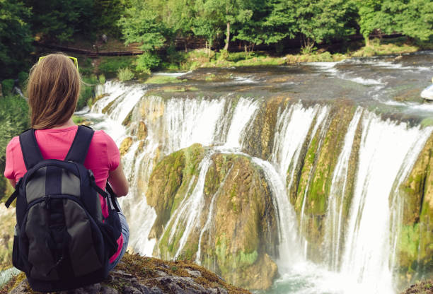 istock Young woman backpacker enjoying the waterfalls view 1125418199