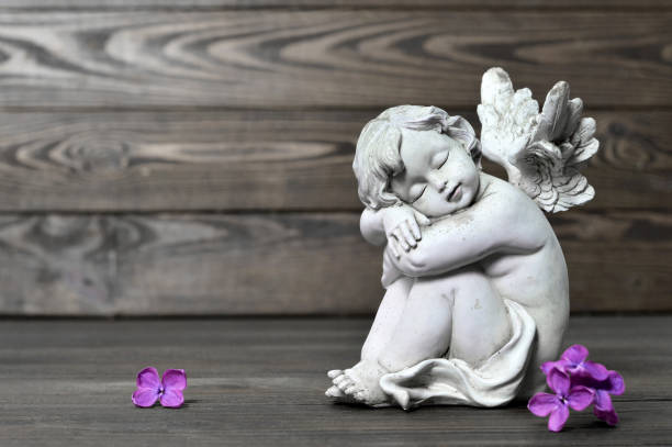 istock Angel guardian sleeping on wooden background 1125418429