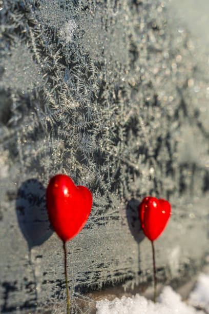 istock Blurred Read Heart Decorations on the Foreground of Window with Hoarfrost - Abstract Background with the Space for Text, Concept of Love and Happiness on Valentines Day 1125424914