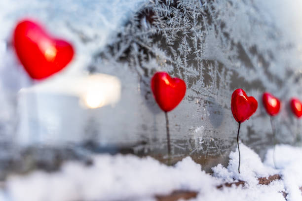 istock Blurred Read Heart Decorations on the Foreground of Window with Hoarfrost - Abstract Background with the Space for Text, Concept of Love and Happiness on Valentines Day 1125424983
