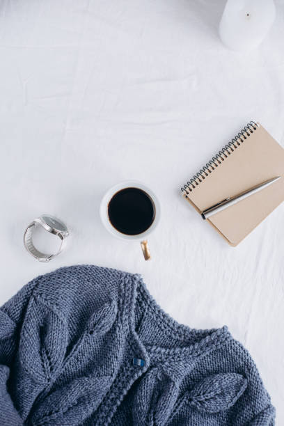 istock Cup coffee , blue knitted sweater, notebook with pen, clock, candle on bed, top view. 1125428992