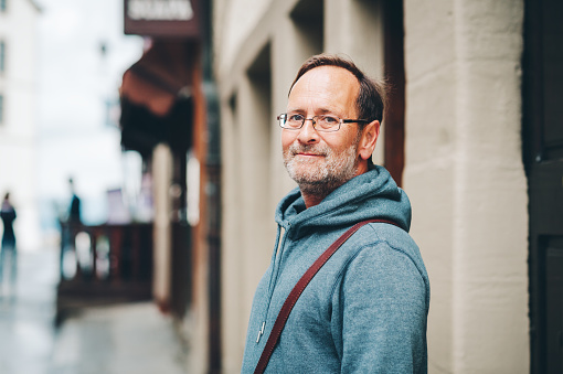 Outdoor portrait of 50 year old man wearing blue hoody and eyeglasses