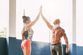 Fitness couple stacking hands in gym wellness club - Happy athletes motivating each other - Concept of people training, fit, empowering and bodybuilding lifestyle