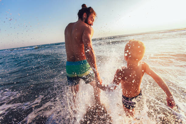 Father and son playing on the beach at the day time