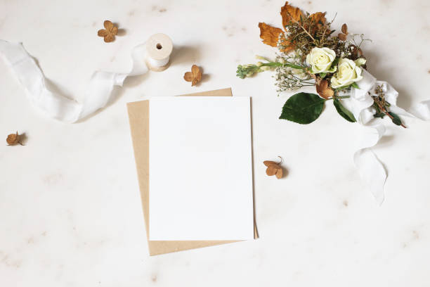 女性の冬の結婚式、誕生日文房具モックアップ シーン。空白のグリーティング カード、封筒。アジサイ、白バラとカスミソウの花束の花を乾燥させます。大理石の石のテーブル背景。フラ� - birthday card envelope invitation blank ストックフォトと画像
