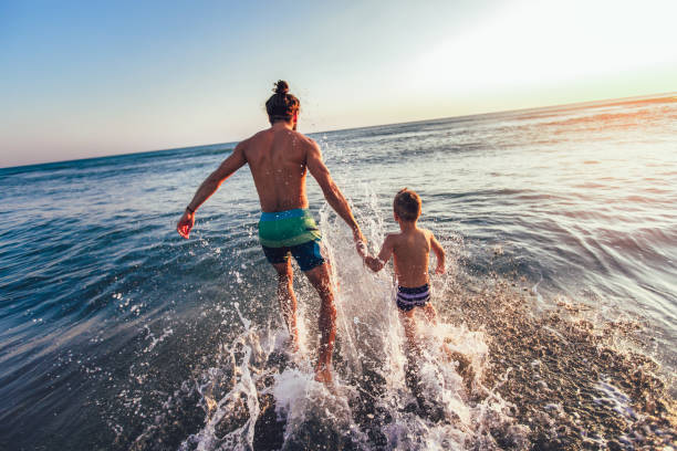 istock Father and son playing on the beach at the day time 1125434566