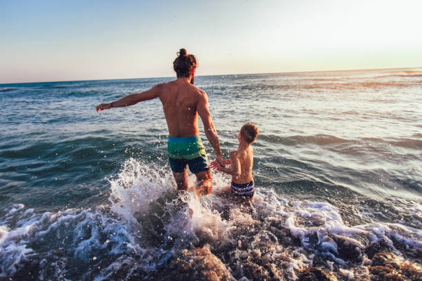 istock Father and son playing on the beach at the day time 1125434678