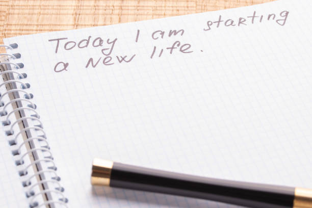 istock Top view workplace notebook and pen on wood table background. Inscription - Today I am starting a new life. 1125434736