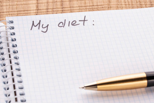 istock Top view workplace notebook and pen on wood table background, retro effect. Inscription - My diet. 1125434777