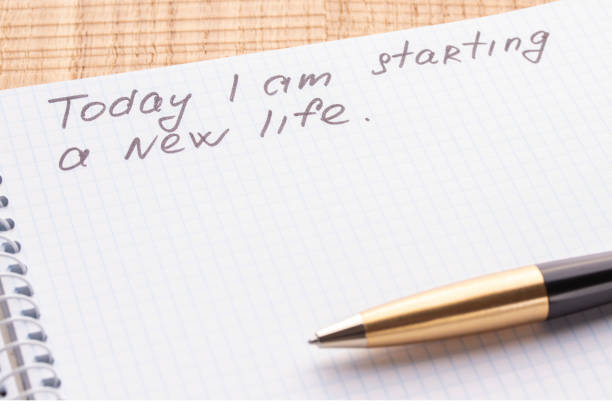 istock Top view workplace notebook and pen on wood table background. Inscription - Today I am starting a new life. 1125434871