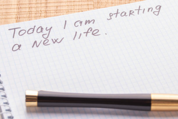 istock Top view workplace notebook and pen on wood table background. Inscription - Today I am starting a new life. 1125434927