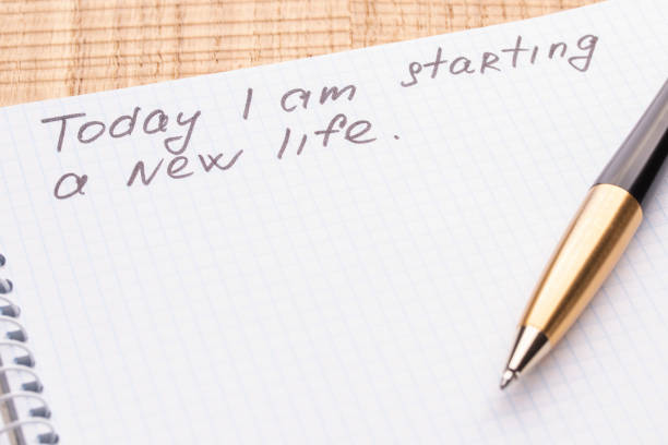istock Top view workplace notebook and pen on wood table background. Inscription - Today I am starting a new life. 1125434974