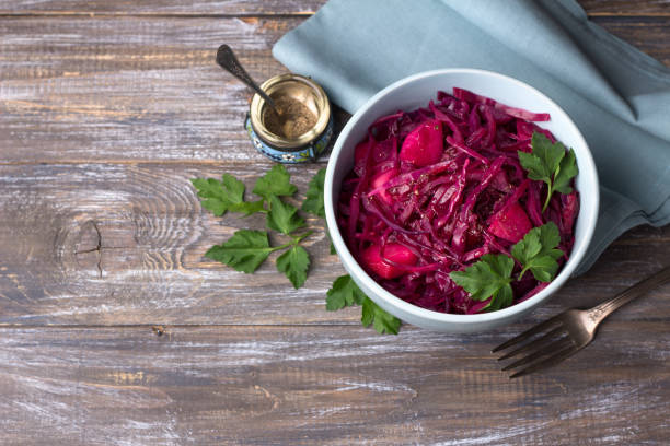 istock Stewed red cabbage with apples, spices and greens on a wooden background 1125436349
