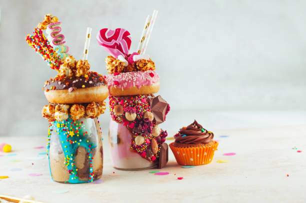 istock Two freak shakes topping with donuts, popcorn and sweets on party background 1125439113