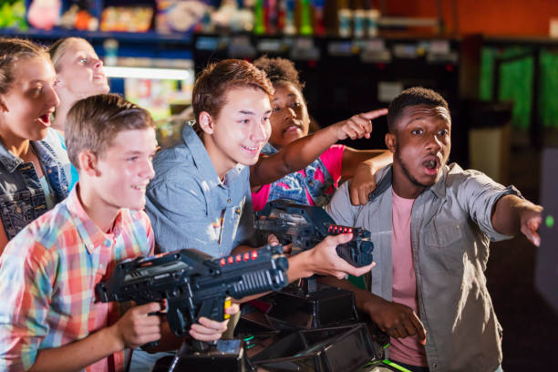 istock Multi-ethnic teenage friends playing arcade games 1125443098