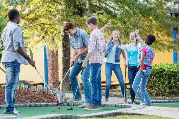 ados, jouer au golf miniature, filles contre garçons - disabled teenager adolescence physical impairment photos et images de collection