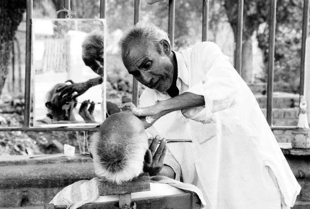 Black and white snapshot of man getting shaved in the streets of Jaipur, India