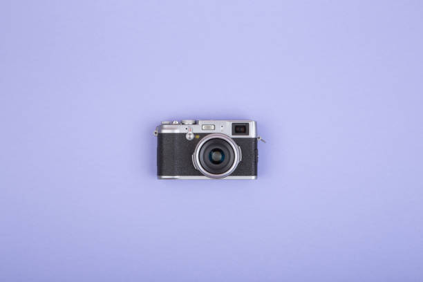 Old fashioned rangefinder camera on purple background, flat view stock photo