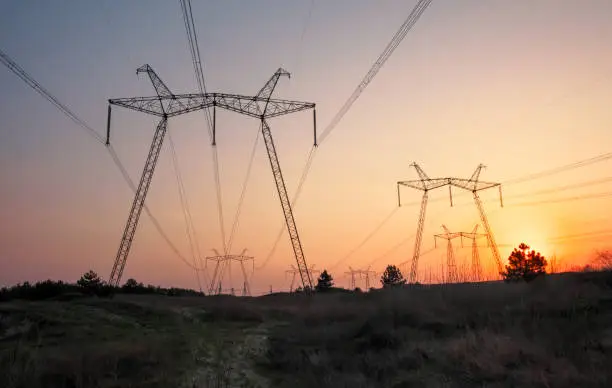 Photo of High-voltage power lines during fiery sunrise