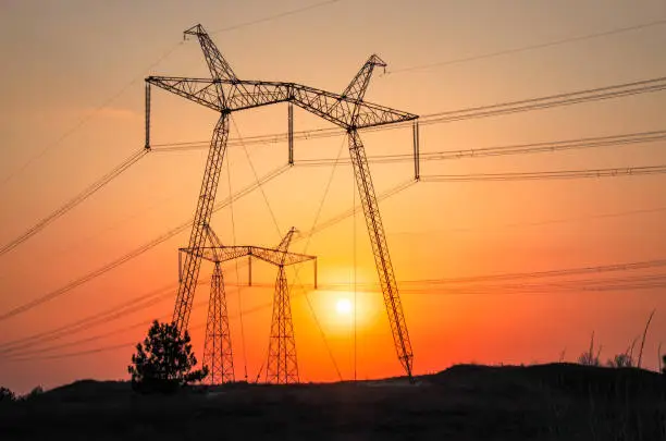 Photo of High-voltage power lines during fiery sunrise