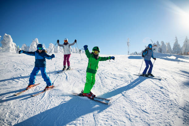 Family having fun skiing together on winter day Mother with kids are skiing together down the ski slope. Everybody is laughing happily. 
Sunny winter day.
Nikon D850 ski photos stock pictures, royalty-free photos & images