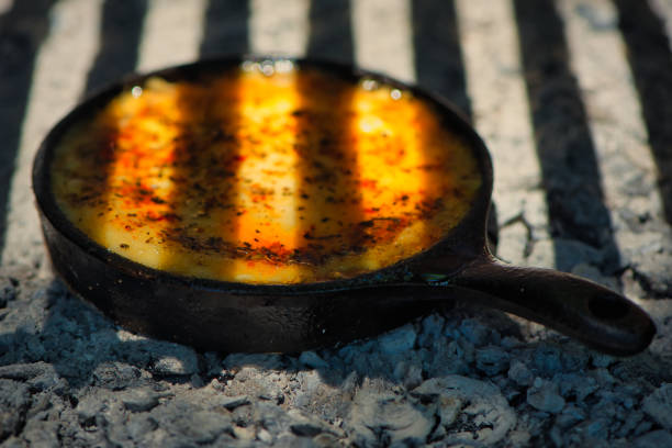 Delicious Argentinian Provolone Yarn Cheese (Provoleta) that is cooked in a cast iron skillet over the embers and ashes, province of Buenos Aires, Argentina. stock photo