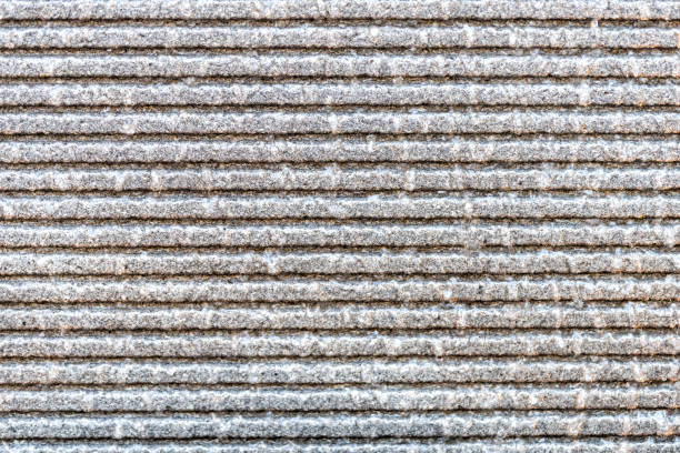 Close-up view of a textured concrete wall with visible vertical dividers, showcasing the rugged surface and granular structure.