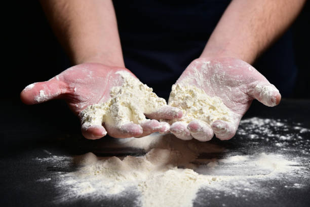 istock Baker pours flour into his hand 1125476444
