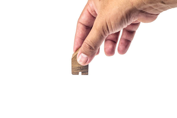 istock House wood miniature with hand on white background  . 1125482338
