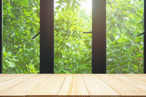 istock black metallic window framEmpty wood table top on black metallic window frame with green tree nature backgrounde with green tree nature background 1125486932