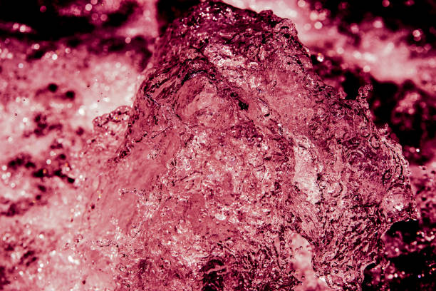 Water smashing a rock, red tinted abstract photograph on a waterfall.