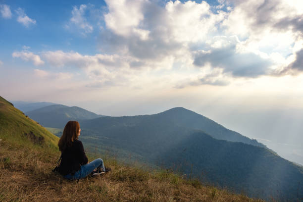 istock A woman sitting and watching sunset with mountains view 1125514075