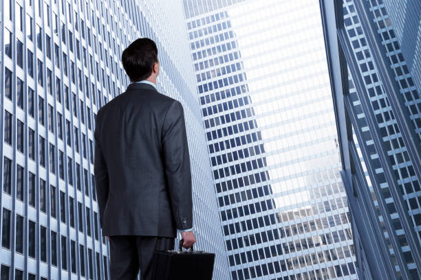 istock Businessman Looking Up At Tall Buildings 1125515236