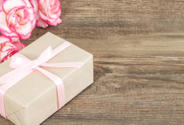 istock Present or gift box in a craft paper with gold ribbon bow 1125521467