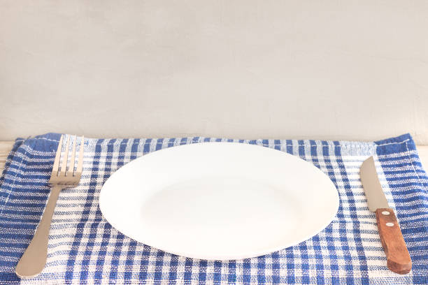 istock Empty plate on tablecloth or napkin on wooden table over cement background 1125521597