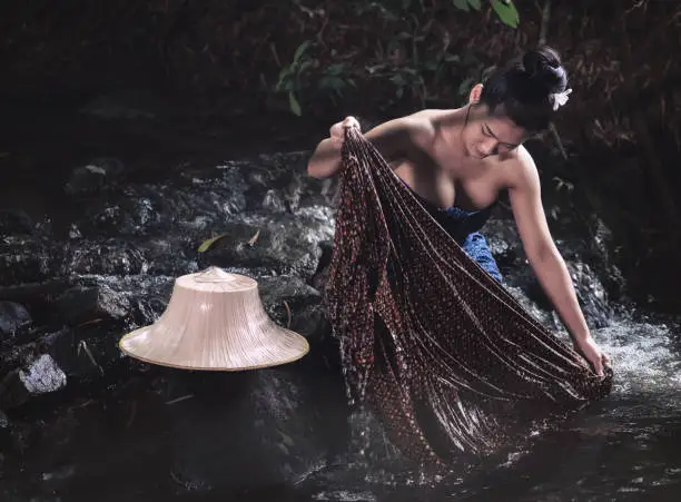 Photo of Woman hands washing clothes at brook.