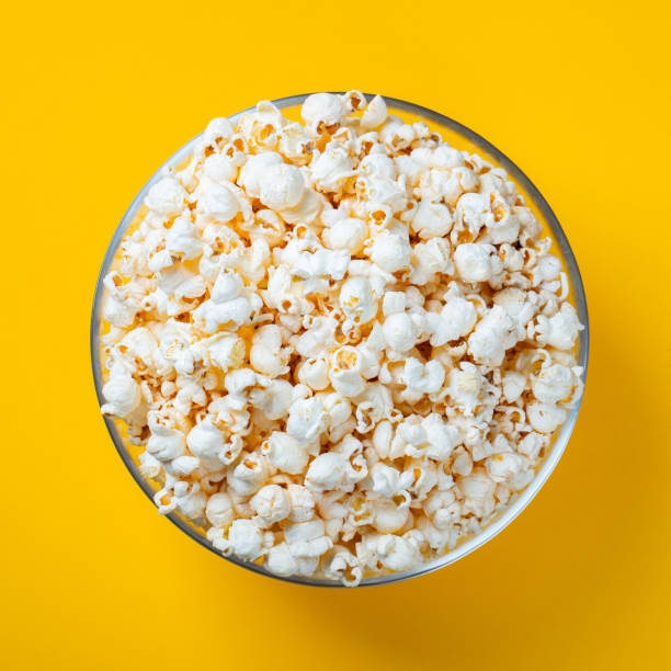 istock Glass bowl with salted popcorn on yellow background. Top view with copy space. Flat lay 1125535828