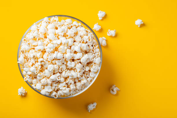 istock Glass bowl with salted popcorn on yellow background. Top view with copy space. Flat lay 1125535836